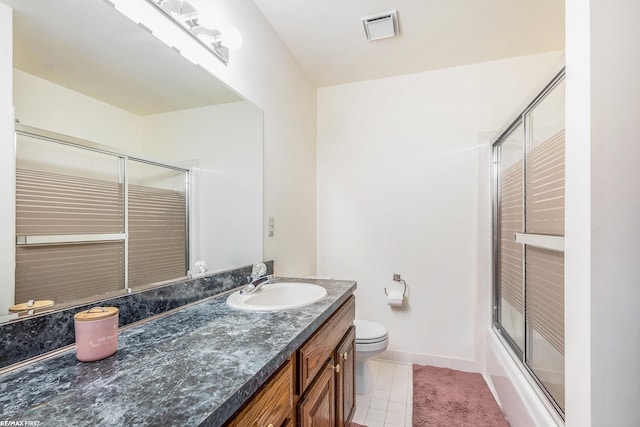 bathroom with vanity, toilet, tile patterned flooring, baseboards, and shower / bath combination with glass door