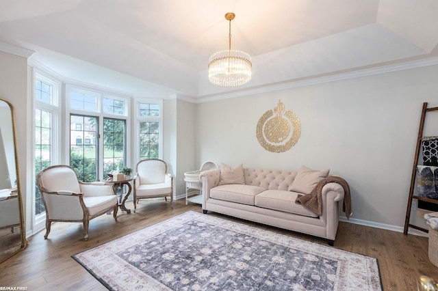 living area with a chandelier, wood finished floors, crown molding, and baseboards