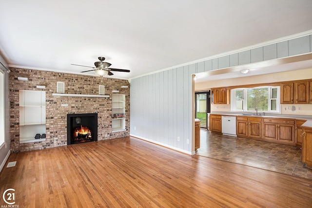 6424 Hunters Creek Rd, Imlay City, MI 48444 - unfurnished living room featuring a ceiling fan, ornamental molding, wood finished floors, a brick fireplace, and baseboards