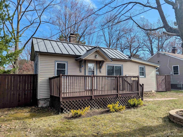 view of front of property with a standing seam roof, a chimney, a wooden deck, and metal roof