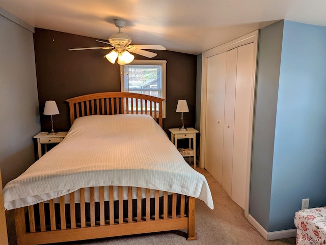 bedroom featuring a closet, light carpet, and ceiling fan