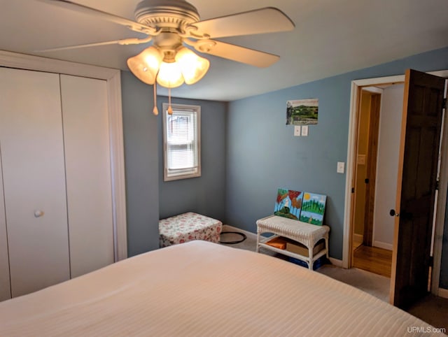 carpeted bedroom with ceiling fan, a closet, and baseboards