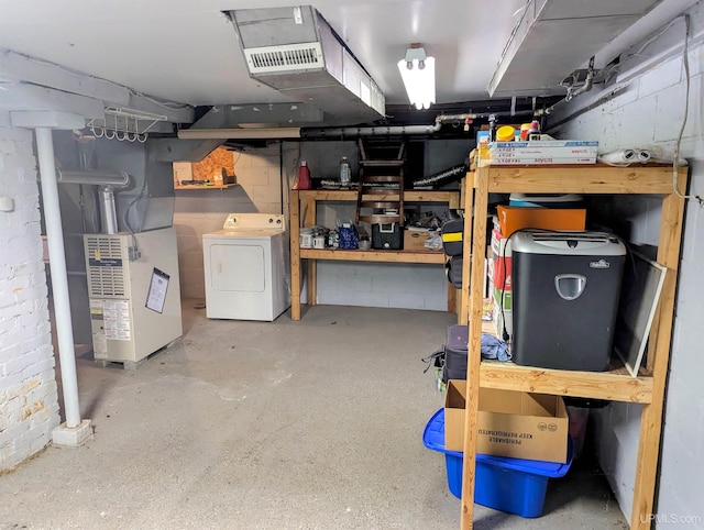 basement featuring washer / clothes dryer, heating unit, and a workshop area