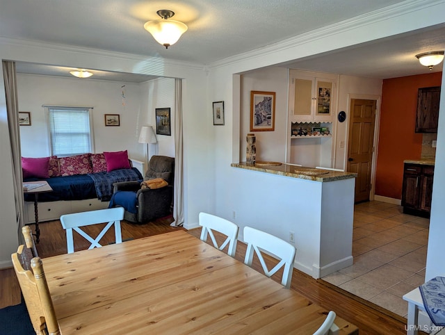 dining area featuring ornamental molding, wood finished floors, and baseboards