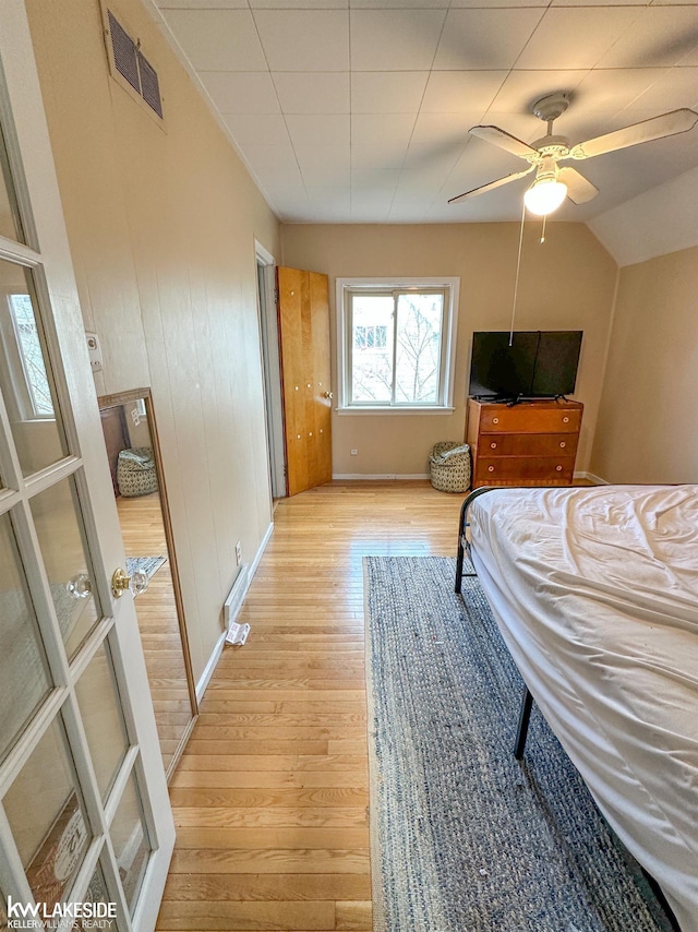 bedroom with light wood-style flooring, baseboards, and ceiling fan