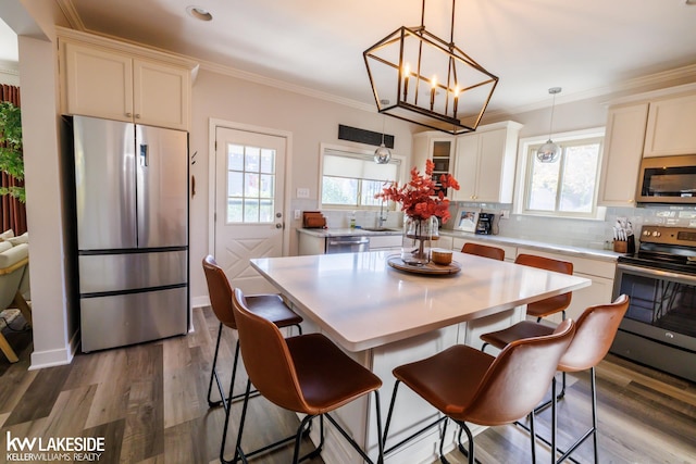 dining area featuring crown molding, plenty of natural light, dark wood-style flooring, and a chandelier