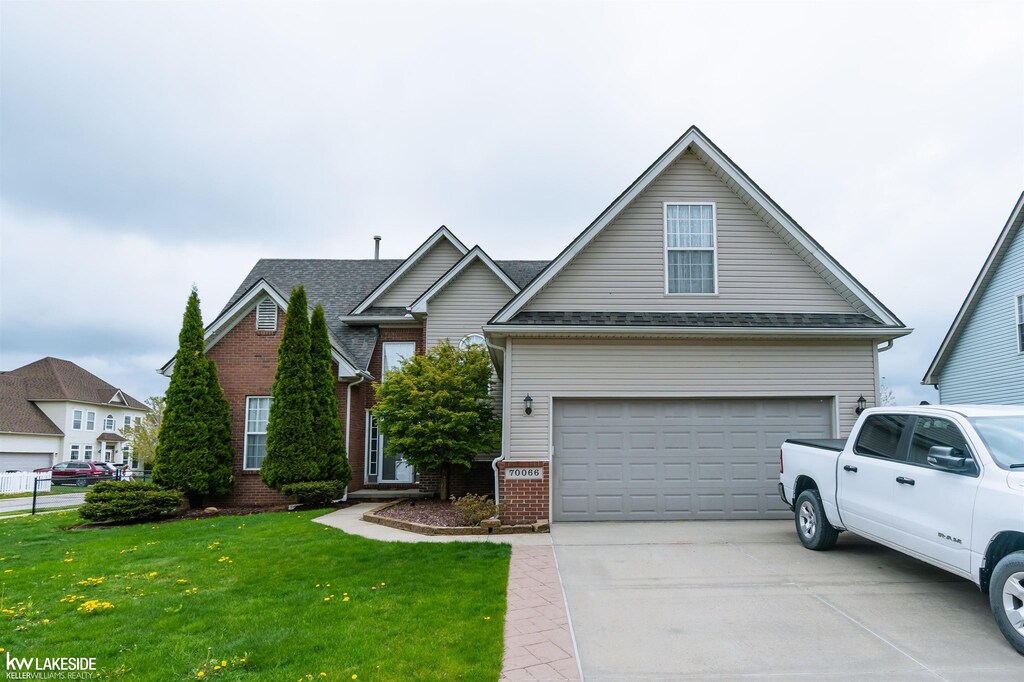 70066 Natures Way, Richmond, MI 48062 - traditional home featuring brick siding, a front yard, concrete driveway, and a garage