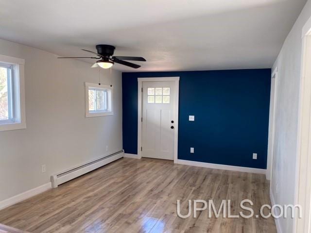 1005 W Brown St, Iron Mountain, MI 49801 - foyer entrance featuring a baseboard radiator, wood finished floors, a ceiling fan, and baseboards