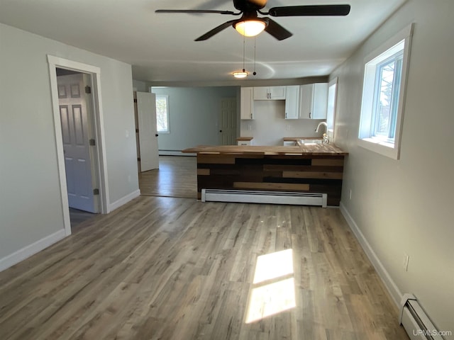1005 W Brown St, Iron Mountain, MI 49801 - kitchen featuring a baseboard radiator, white cabinetry, a ceiling fan, and light wood finished floors