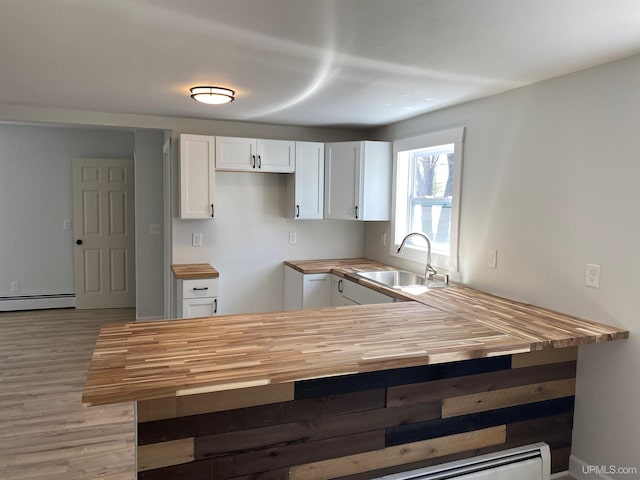 1005 W Brown St, Iron Mountain, MI 49801 - kitchen featuring butcher block counters, a sink, a peninsula, white cabinets, and light wood finished floors