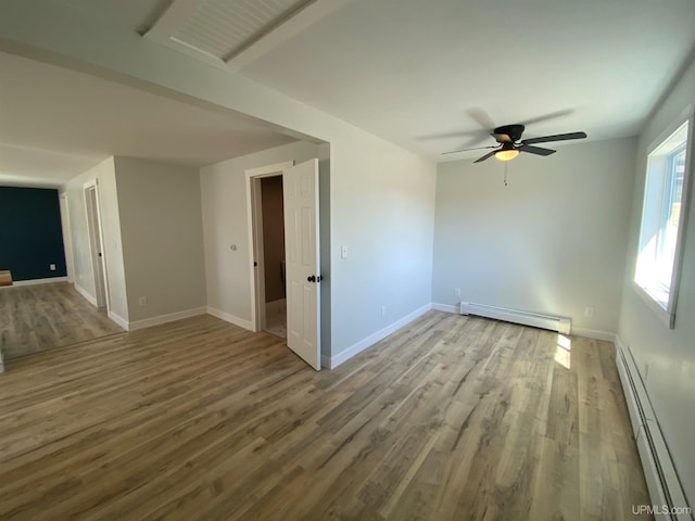 1005 W Brown St, Iron Mountain, MI 49801 - unfurnished room with a baseboard heating unit, wood finished floors, a ceiling fan, and baseboards