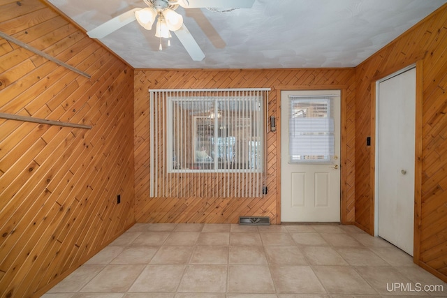 25358 Branch Rd, Michigamme, MI 49861 - spare room with wood walls, ceiling fan, and light tile patterned flooring