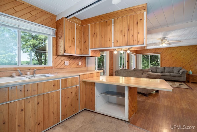 25358 Branch Rd, Michigamme, MI 49861 - kitchen with light countertops, wood walls, a ceiling fan, a sink, and beamed ceiling