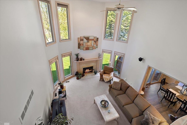 53633 Cherrywood Dr, Shelby Twp, MI 48315 - living room featuring a towering ceiling, healthy amount of natural light, a warm lit fireplace, and a ceiling fan