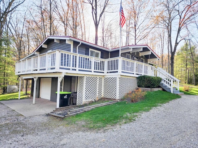 view of side of property with concrete driveway, a wooden deck, and a garage