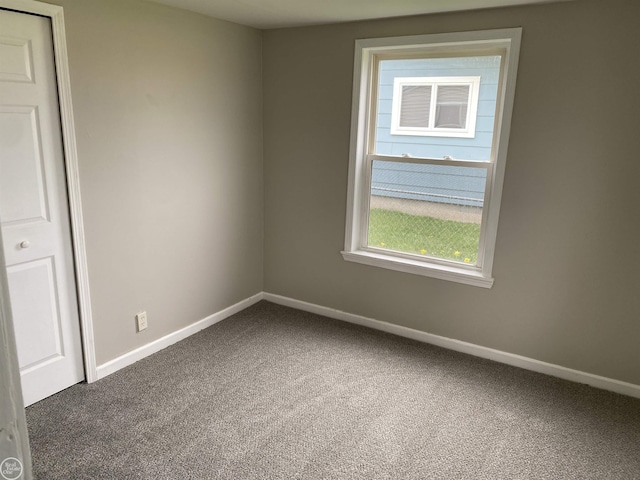 carpeted empty room with baseboards