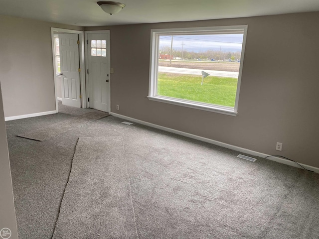 carpeted empty room featuring baseboards