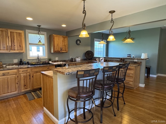 6403 N 1st St, Wells, MI 49894 - kitchen with a sink, light wood-style flooring, a kitchen breakfast bar, healthy amount of natural light, and recessed lighting