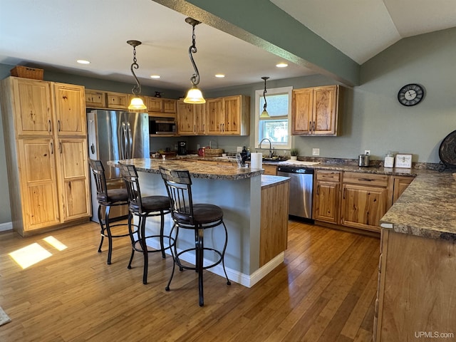 6403 N 1st St, Wells, MI 49894 - kitchen featuring appliances with stainless steel finishes, a kitchen bar, wood finished floors, recessed lighting, and a kitchen island