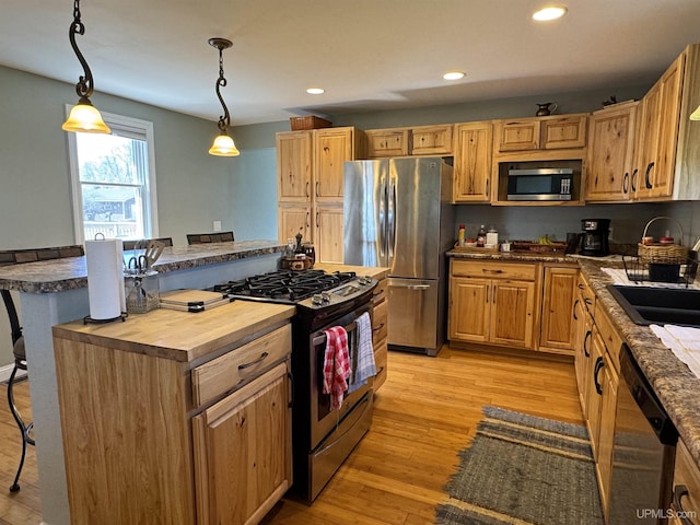 6403 N 1st St, Wells, MI 49894 - kitchen featuring appliances with stainless steel finishes, butcher block counters, a breakfast bar, recessed lighting, and light wood-style floors