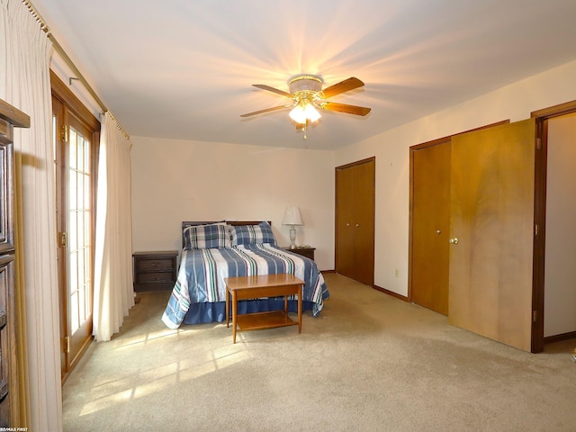 carpeted bedroom featuring two closets and a ceiling fan