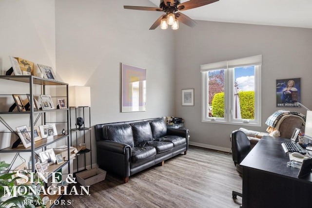 office area featuring wood finished floors, a ceiling fan, baseboards, and high vaulted ceiling