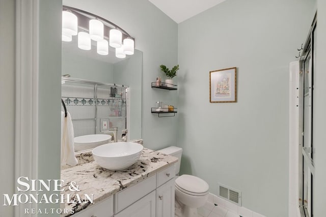 full bath with a stall shower, toilet, vanity, and tile patterned flooring