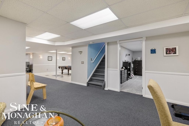 finished below grade area with carpet, stairs, billiards table, a drop ceiling, and baseboards
