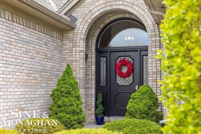 doorway to property featuring brick siding