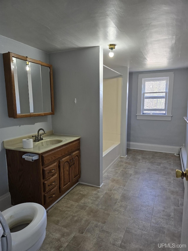 118 S Tamarack St, Laurium, MI 49913 - bathroom featuring vanity, baseboards, tub / shower combination, stone finish flooring, and toilet