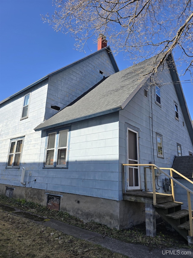 118 S Tamarack St, Laurium, MI 49913 - view of home's exterior featuring a chimney and roof with shingles