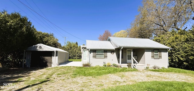 view of front of property with a front yard, metal roof, and an outdoor structure