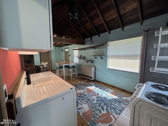 laundry room with wood walls, wood finished floors, cabinet space, and wood ceiling