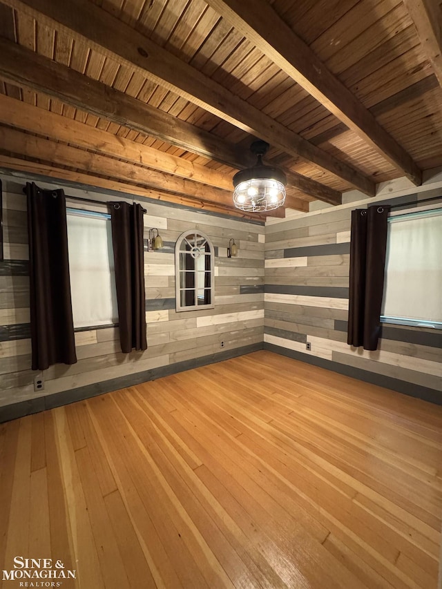 unfurnished room with hardwood / wood-style flooring, wood walls, beamed ceiling, wood ceiling, and a relaxing sauna