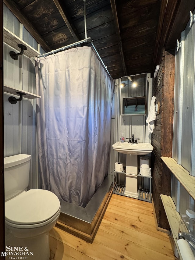 full bath featuring wood walls, wood-type flooring, toilet, and a shower with curtain