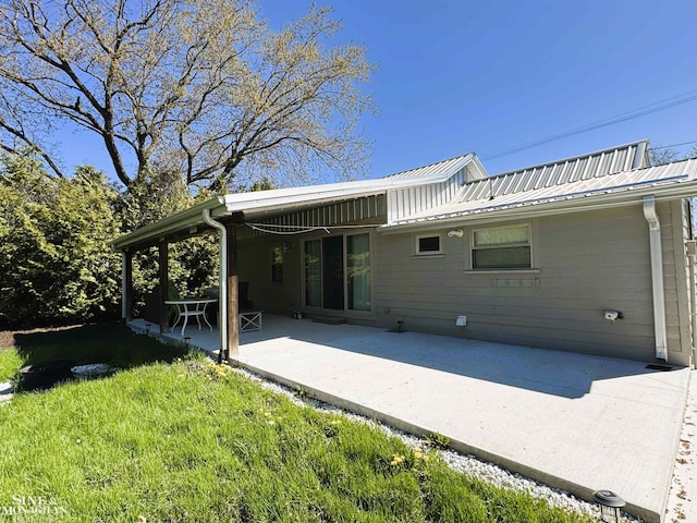 back of house with a patio area, metal roof, and a lawn