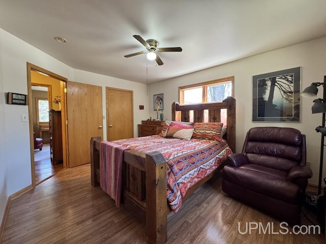 698 E River Dr, Lanse, MI 49946 - bedroom with wood finished floors, multiple windows, and a ceiling fan