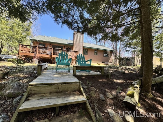 698 E River Dr, Lanse, MI 49946 - back of house with a wooden deck and a chimney