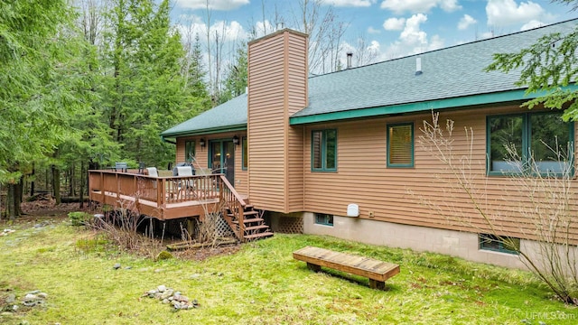 698 E River Dr, Lanse, MI 49946 - back of house with a chimney, a deck, a lawn, and a shingled roof