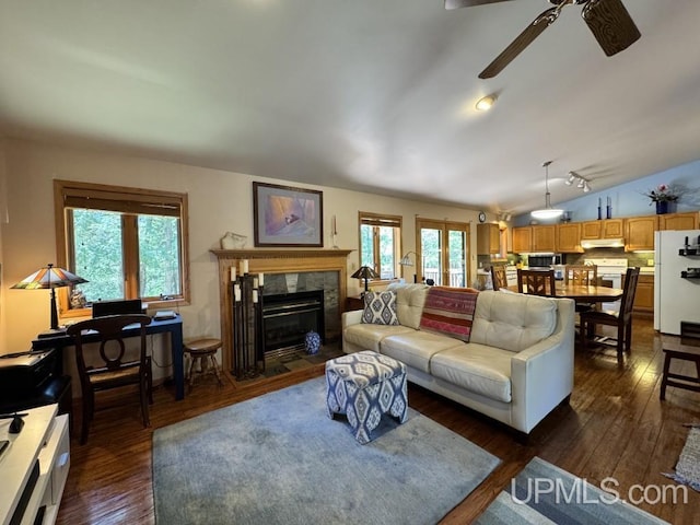 698 E River Dr, Lanse, MI 49946 - living room with ceiling fan, dark wood finished floors, a tile fireplace, and vaulted ceiling