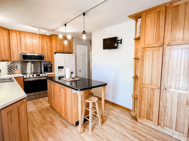 2246 Allen St, Marquette, MI 49855 - kitchen with appliances with stainless steel finishes, light wood-style floors, a kitchen island, a breakfast bar, and track lighting