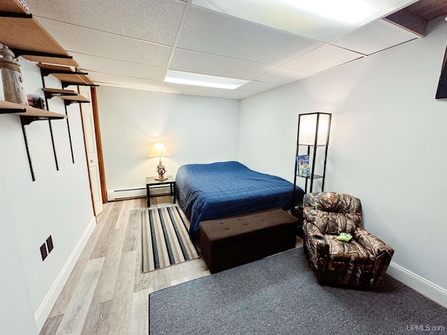 2246 Allen St, Marquette, MI 49855 - bedroom featuring light wood-type flooring, a paneled ceiling, baseboards, and a baseboard heating unit