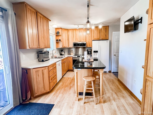 2246 Allen St, Marquette, MI 49855 - kitchen featuring appliances with stainless steel finishes, a sink, light wood finished floors, open shelves, and a kitchen island