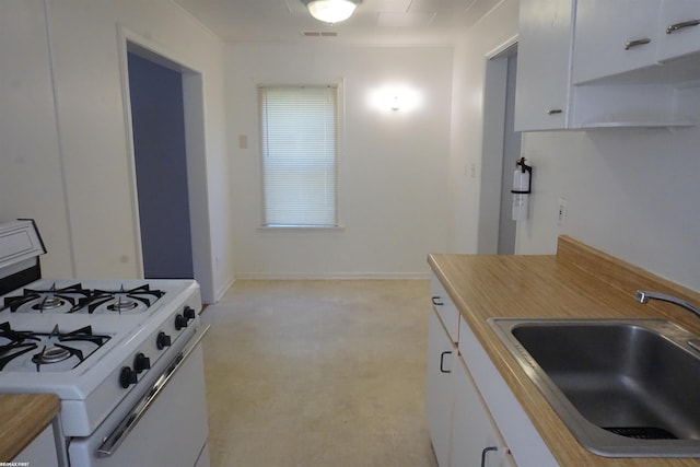 26333 Belanger St, Roseville, MI 48066 - kitchen featuring white gas range oven, a sink, white cabinetry, and light colored carpet