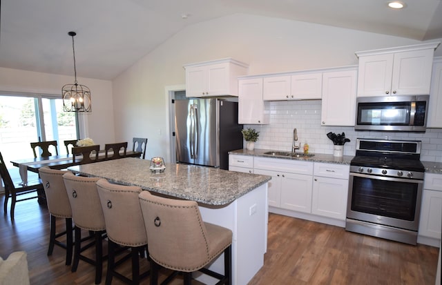 7272 S 7 Mile Rd, Freeland, MI 48623 - kitchen featuring stainless steel appliances, a sink, lofted ceiling, a center island, and a breakfast bar
