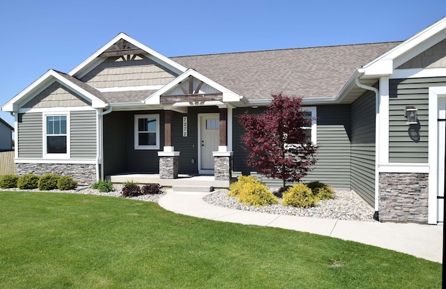 7272 S 7 Mile Rd, Freeland, MI 48623 - craftsman inspired home featuring stone siding, a porch, a front yard, and roof with shingles