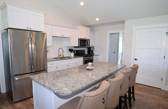 7272 S 7 Mile Rd, Freeland, MI 48623 - kitchen featuring stainless steel appliances, a sink, vaulted ceiling, white cabinets, and backsplash