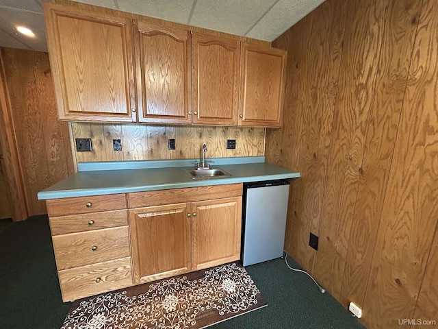 3260 Herron Dr, Gwinn, MI 49841 - kitchen with a sink, dishwashing machine, wood walls, light countertops, and dark carpet