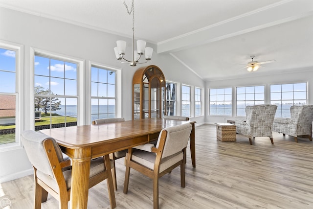 dining area with a water view, a chandelier, light wood-style floors, baseboards, and crown molding