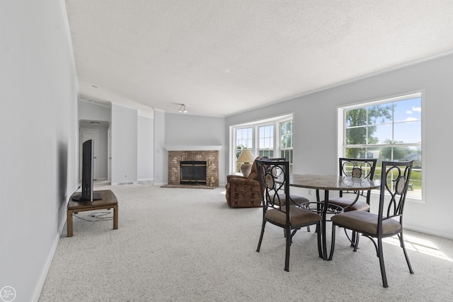 carpeted dining area featuring baseboards, a brick fireplace, and a textured ceiling